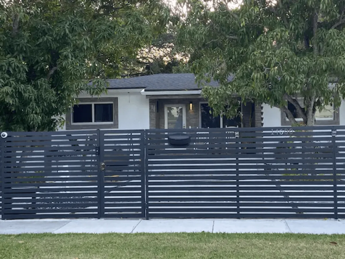 A welcoming view of the villa's exterior featuring a modern gate, a cozy front porch, and a landscaped yard. The space is designed for gatherings, with ample room for families to relax outdoors, host barbecues, or enjoy time together after exploring local attractions.